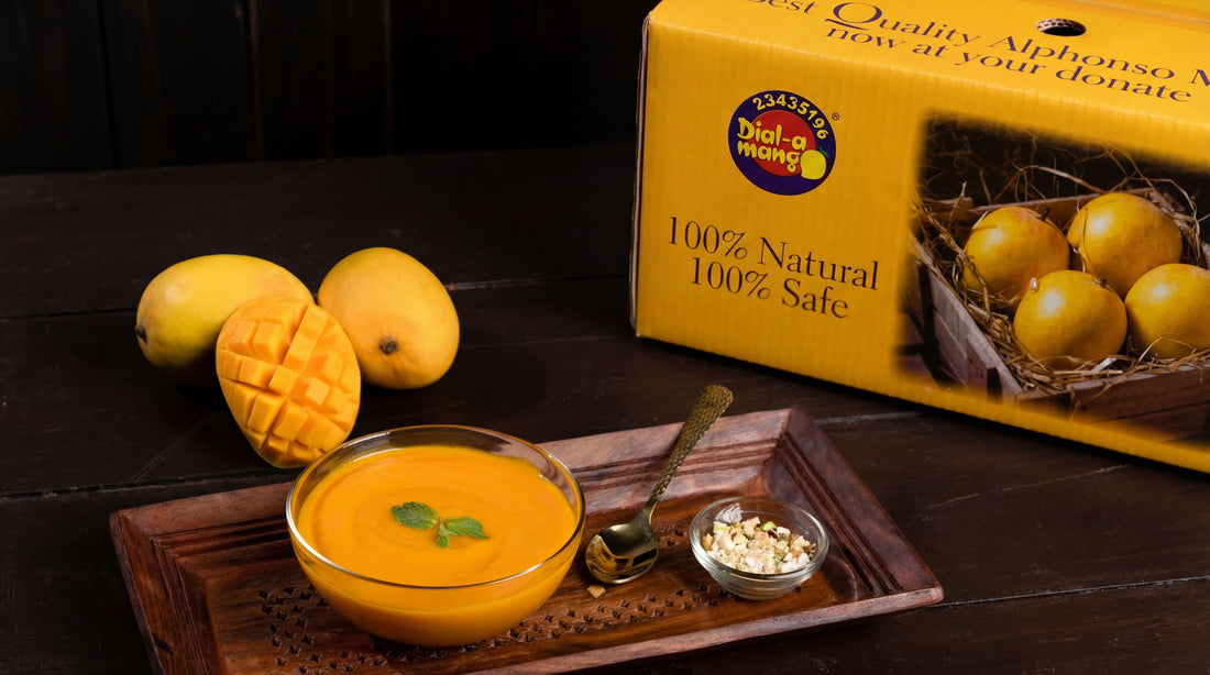 A bowl of mango aamras, fresh mangoes, and a packaged alphonso box arranged on a dark wooden table.