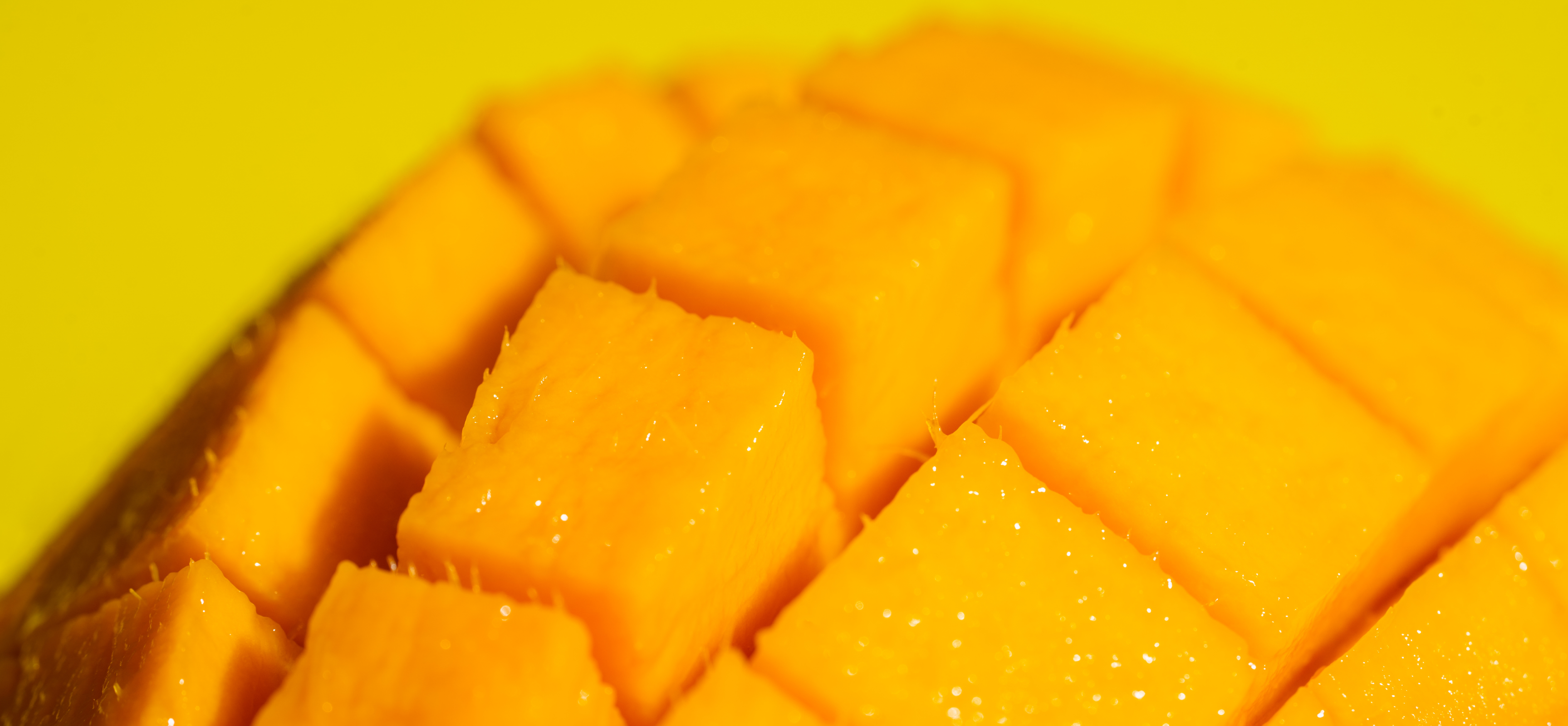 Close-up of ripe Alphonso mango cut into juicy cubes, showing bright golden pulp and smooth, glistening texture. alphonso mango online